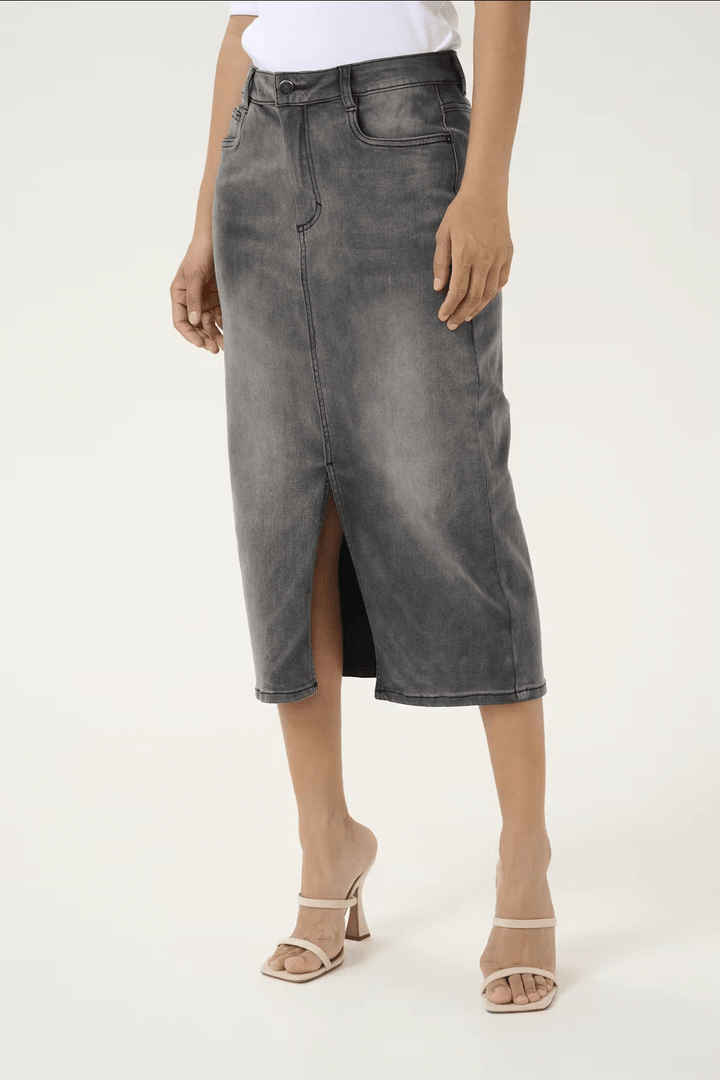 Jupe longue Sinem en denim gris, taille haute avec fente avant, associée à des sandales à talons pour un look chic.