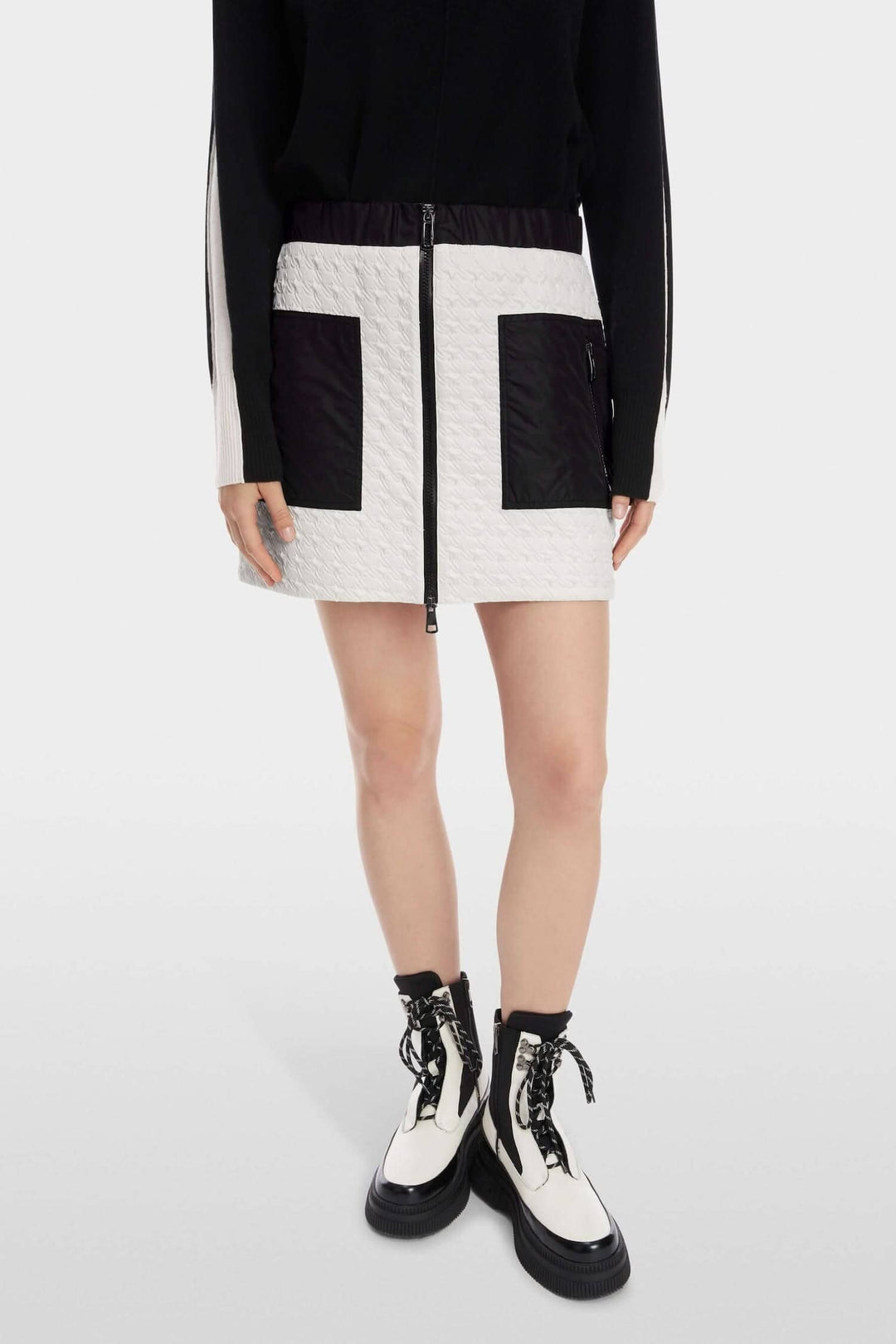 Mini-jupe matelassée avec poches zippées et fermeture éclair, style sportif et décontracté.