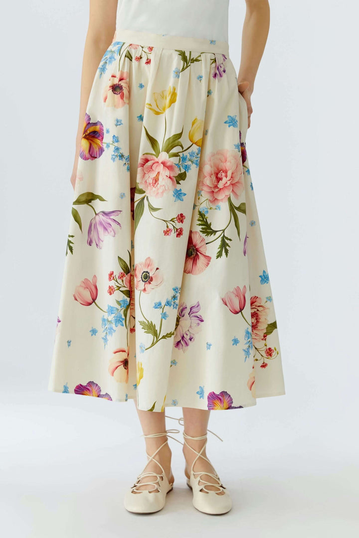 Jupe mi-longue imprimé de fleurs avec taille structurée et coupe évasée élégante, offrant un style féminin et polyvalent.