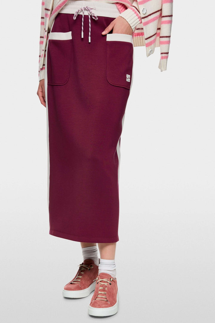 Jupe midi sportive bordeaux avec poches et cordon, bandes contrastées sur les côtés, fente arrière, logo Marc Cain Sports.