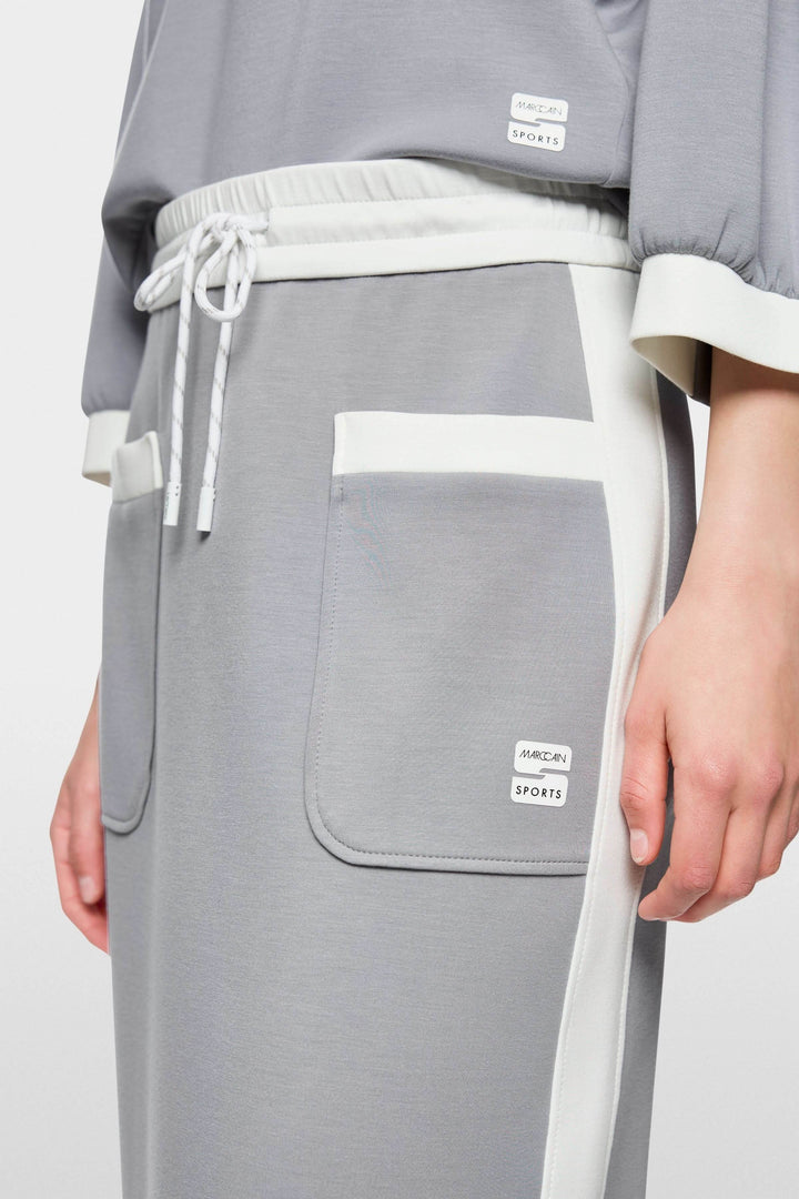 Jupe midi sportive avec cordon de serrage, bandes contrastées et logo Marc Cain Sports, détail des poches et taille élastiquée.
