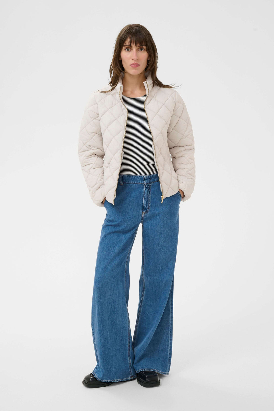 Manteau Olia matelassé beige porté avec style moderne et pratique sur un modèle, coupe droite, col montant, idéal pour temps frais.