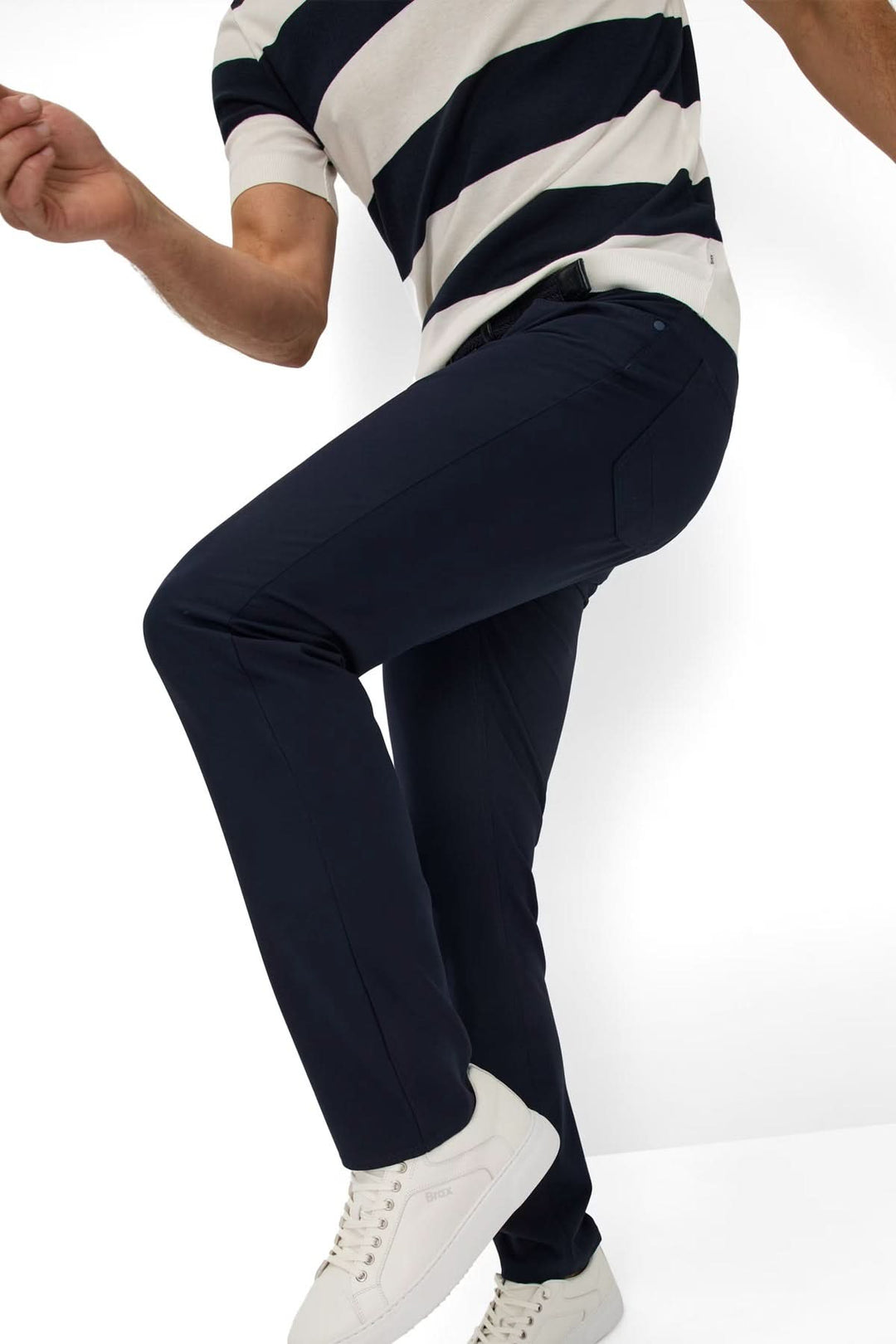 Homme portant le Pantalon Chuck noir, coupe droite, avec t-shirt rayé et chaussures blanches, pour un look moderne et confortable.