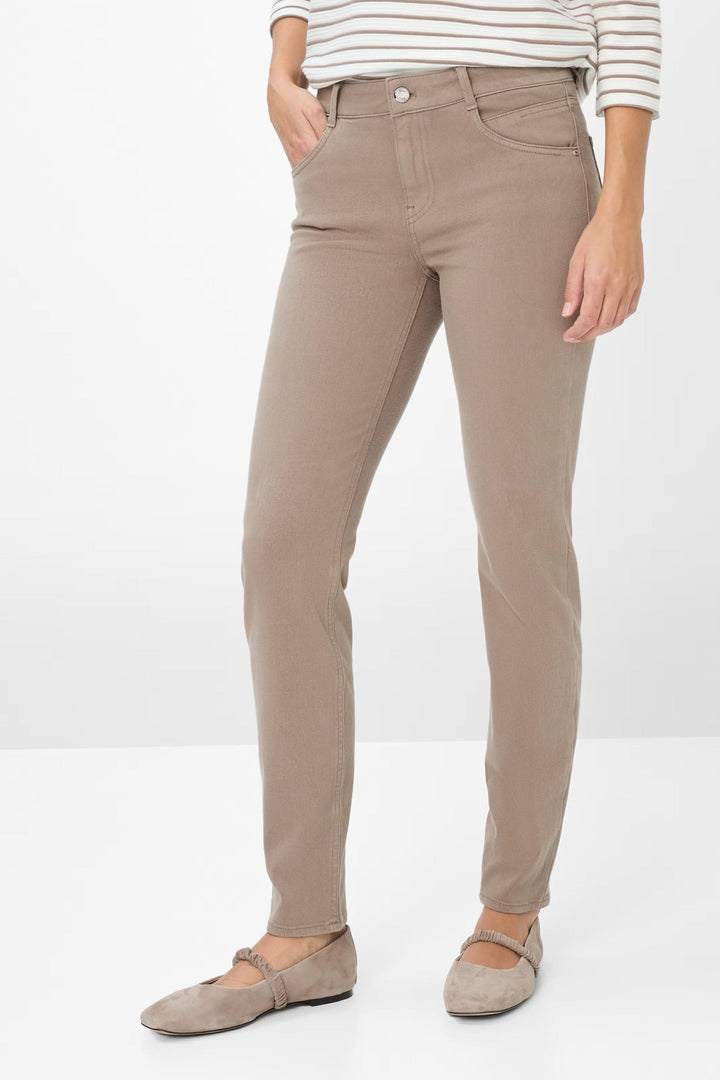 Femme portant le Pantalon Shakira ajusté beige, taille mi-haute, pour un look chic. Idéal avec un chandail rayé. Confort et élégance.