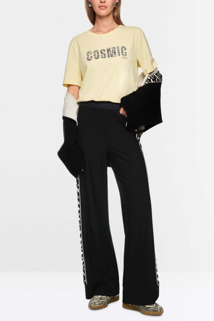 Pantalon WELKOM avec bande latérale imprimée animalier, coupe large et longue pour un confort optimal, modèle durable.