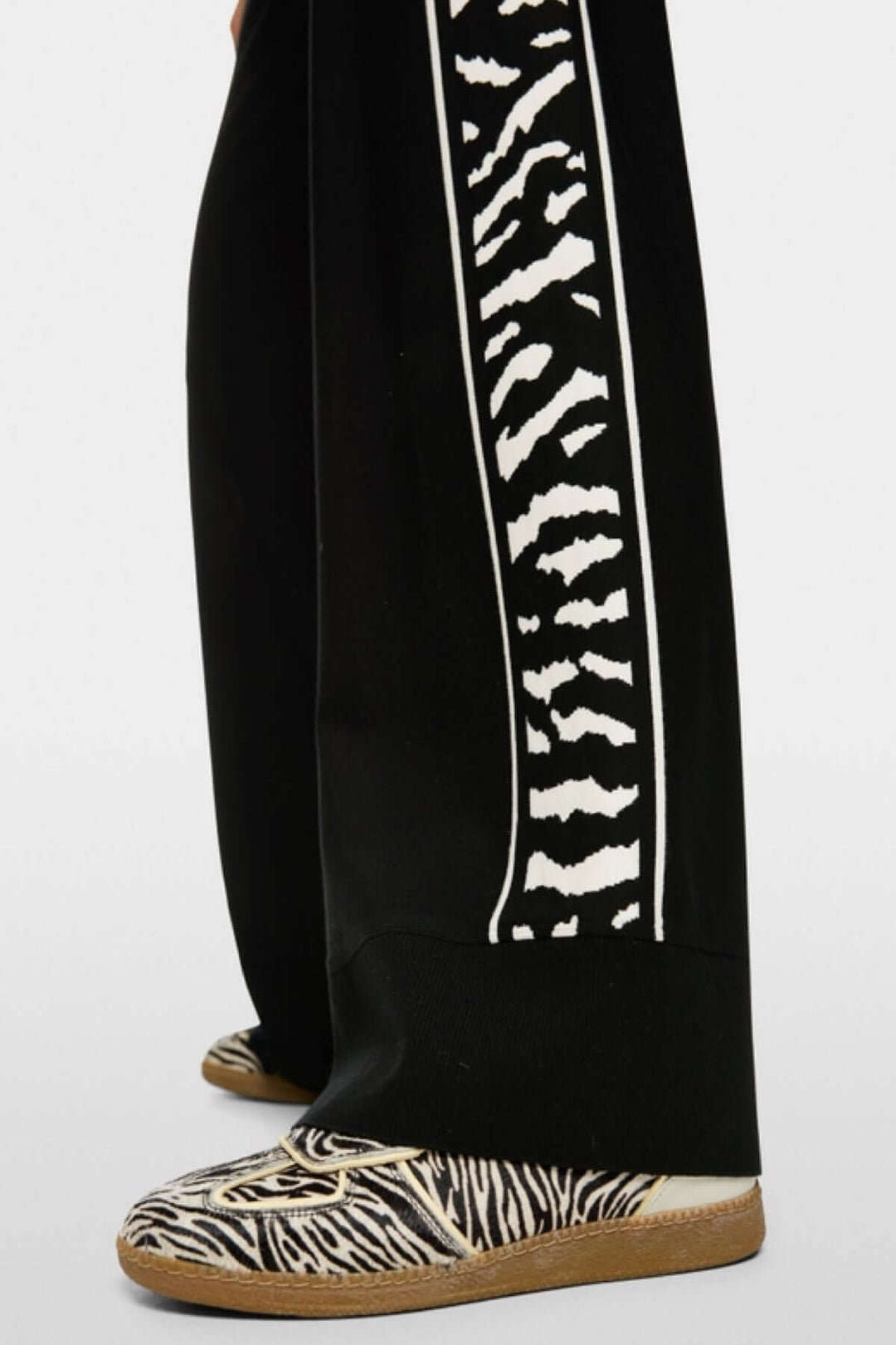Pantalon WELKOM à coupe large avec bande latérale imprimé animalier et ourlet en bord-côte, fabriqué durablement, vue latérale.