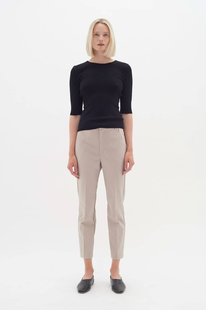 Modèle portant le pantalon Ziggi beige avec un haut noir, mettant en avant un style décontracté et élégant.
