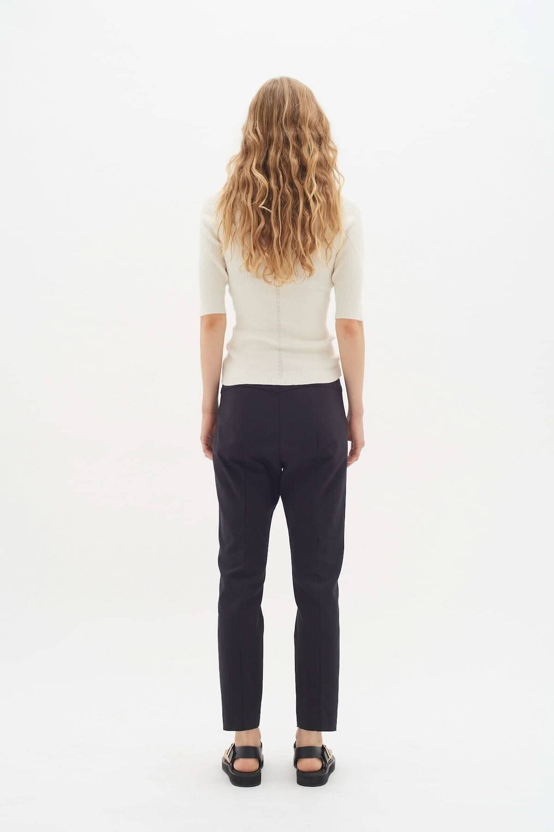 Femme vue de dos portant le pantalon Ziggi noir avec un top beige, mettant en avant le style décontracté et élégant.