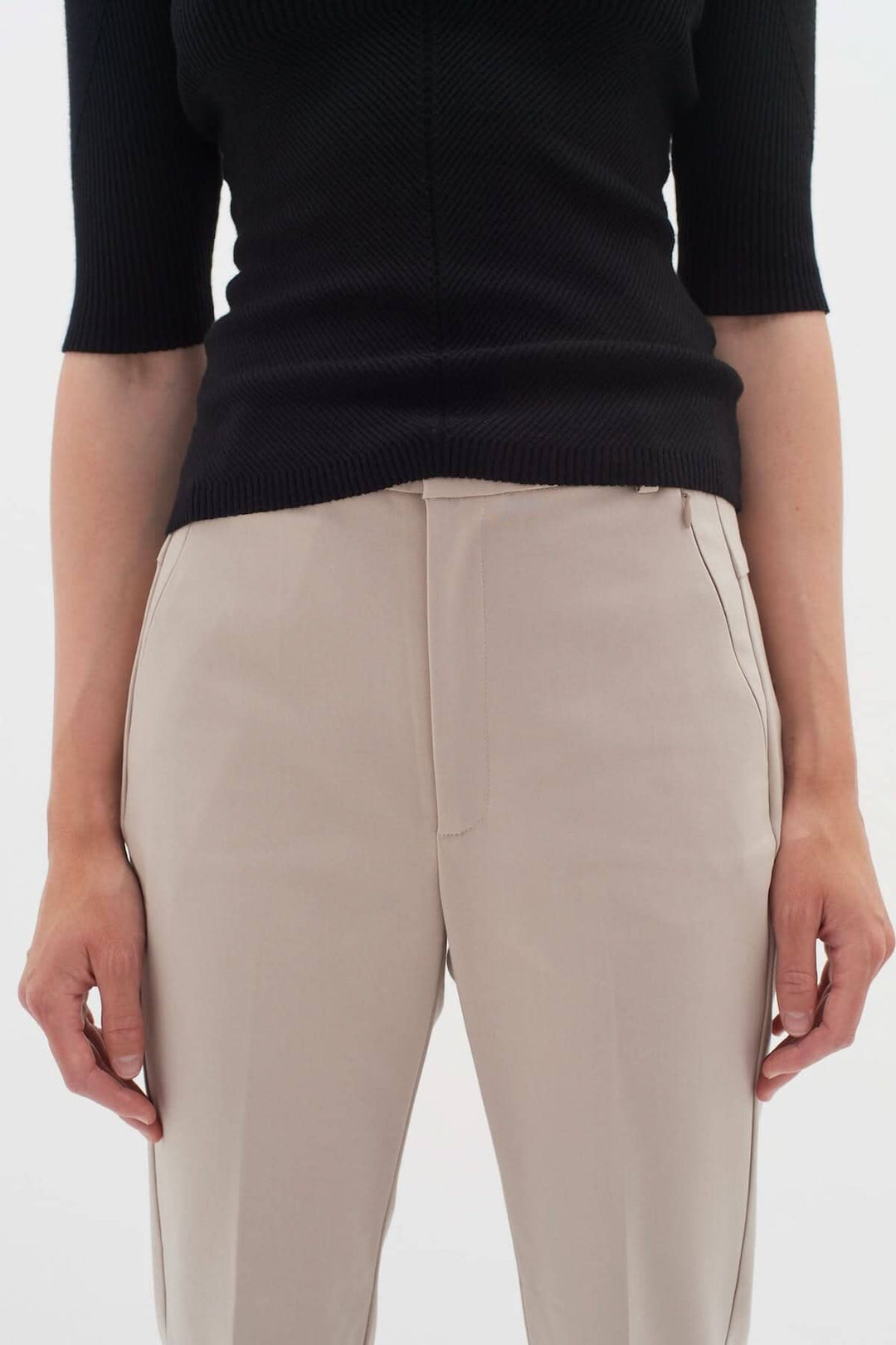 Pantalon Ziggi beige avec coupe ajustée, porté avec un haut noir, mettant en valeur un style décontracté et élégant.