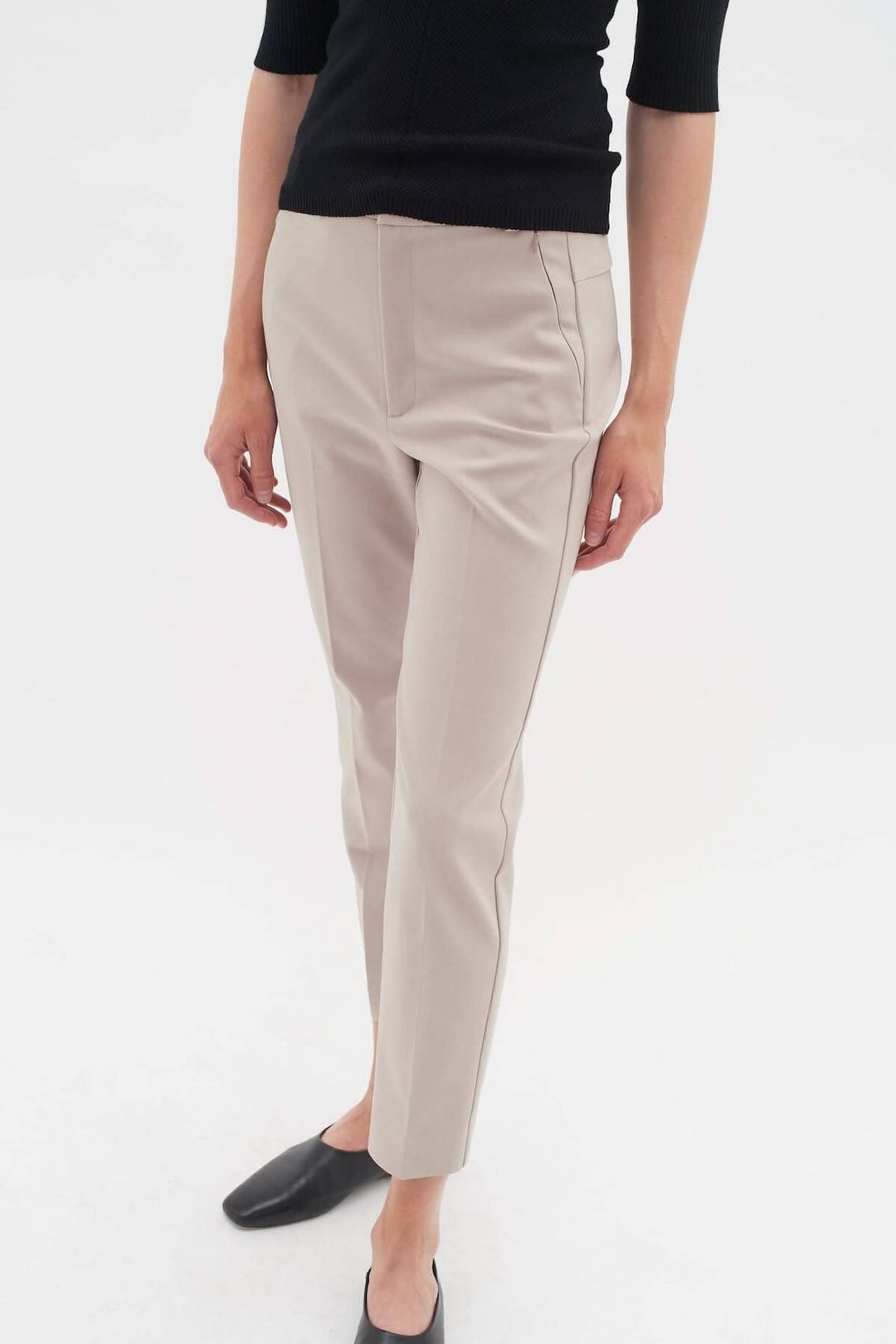 Pantalon Ziggi beige avec coupe ajustée et poches zippées, porté par un mannequin en noir.