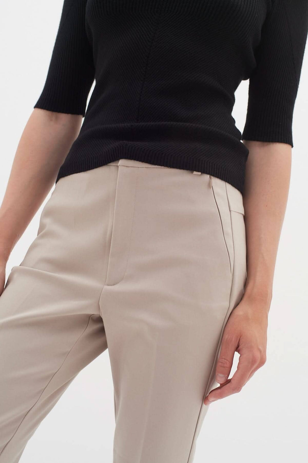 Pantalon Ziggi en beige, avec coupe ajustée et poches zippées, modèle élégant et décontracté.