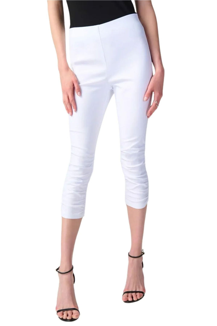 Pantalon capri blanc avec ceinture extensible, fronces sur les côtés et coupes arrière au niveau des genoux.