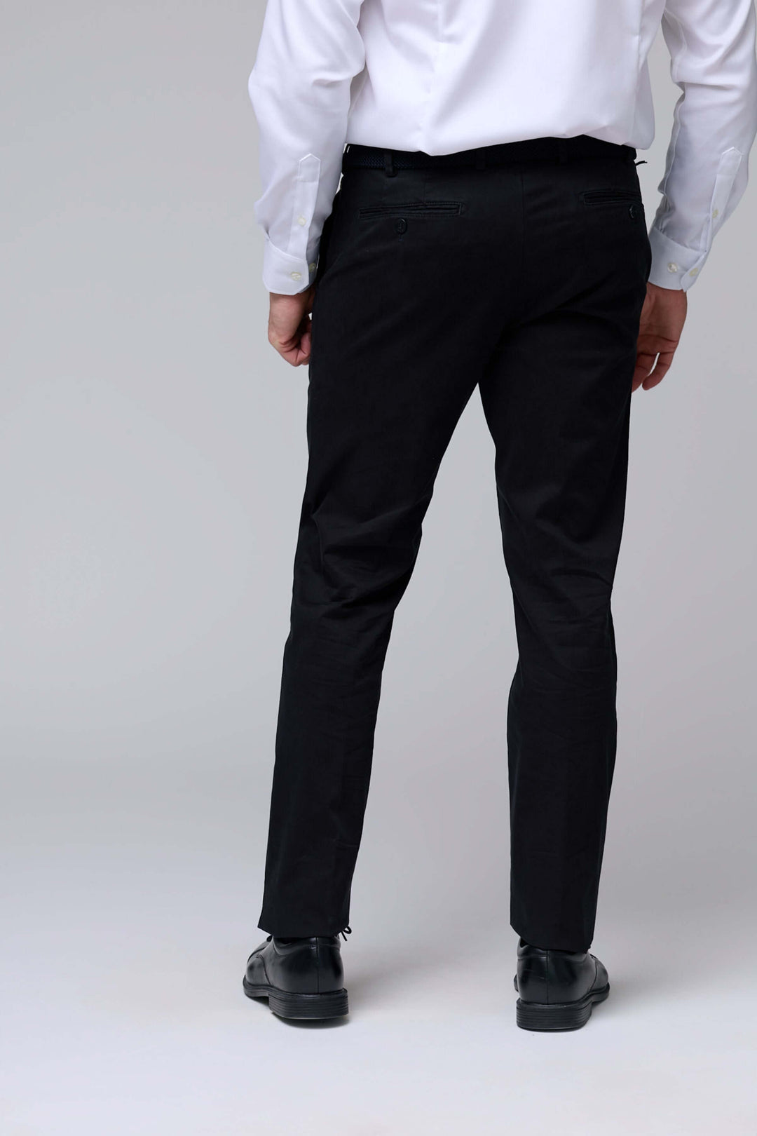 Pantalon chino ajusté noir pour homme avec coupe moderne et tissu extensible, vu de dos.