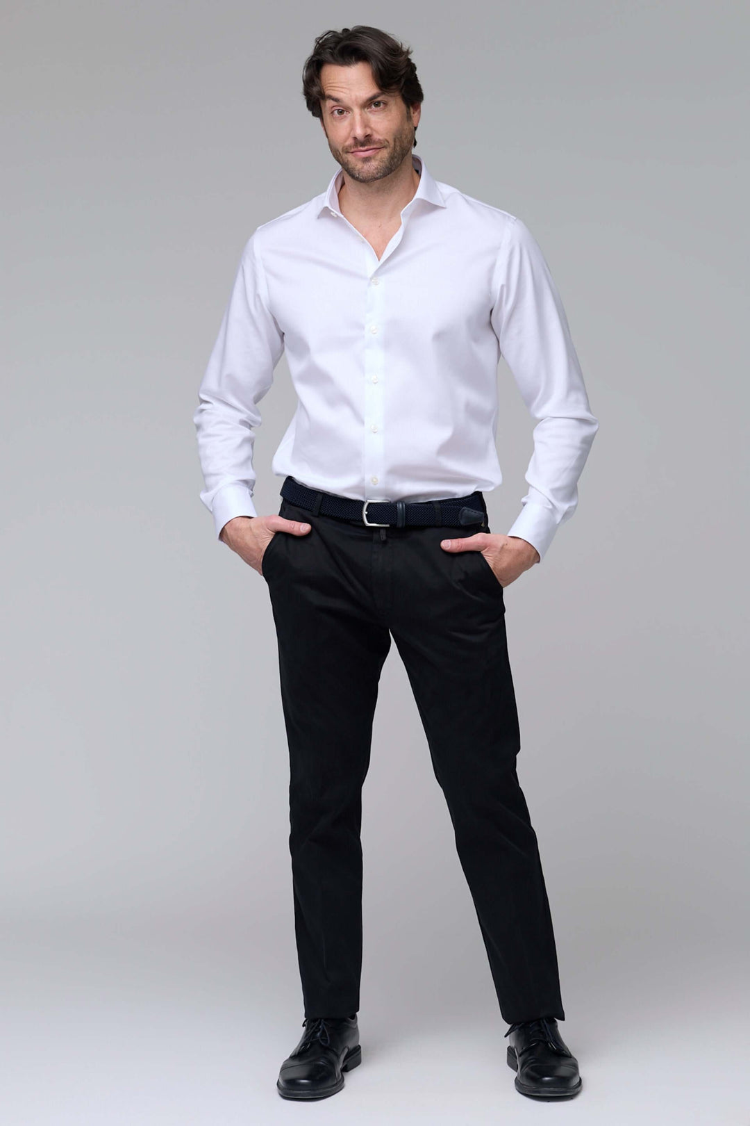 Homme portant un pantalon chino ajusté noir avec chemise blanche, mettant en valeur un style professionnel et décontracté.