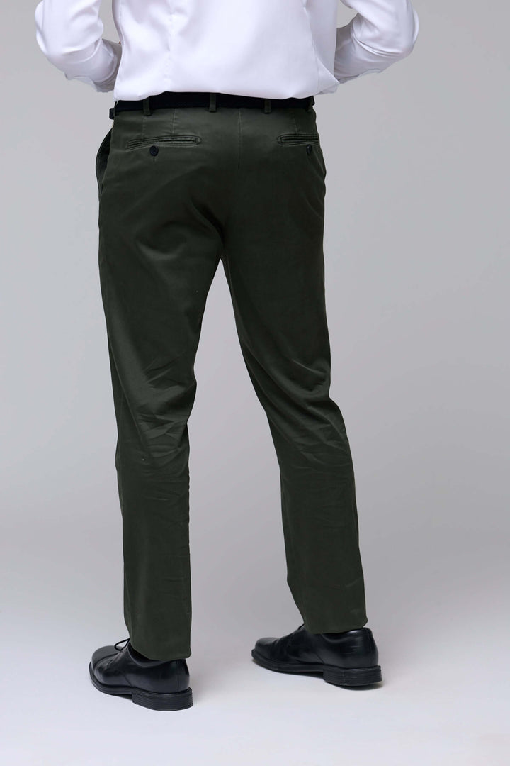 Homme portant pantalon chino ajusté vert foncé, coupe droite légèrement ajustée, parfait pour look professionnel et décontracté.
