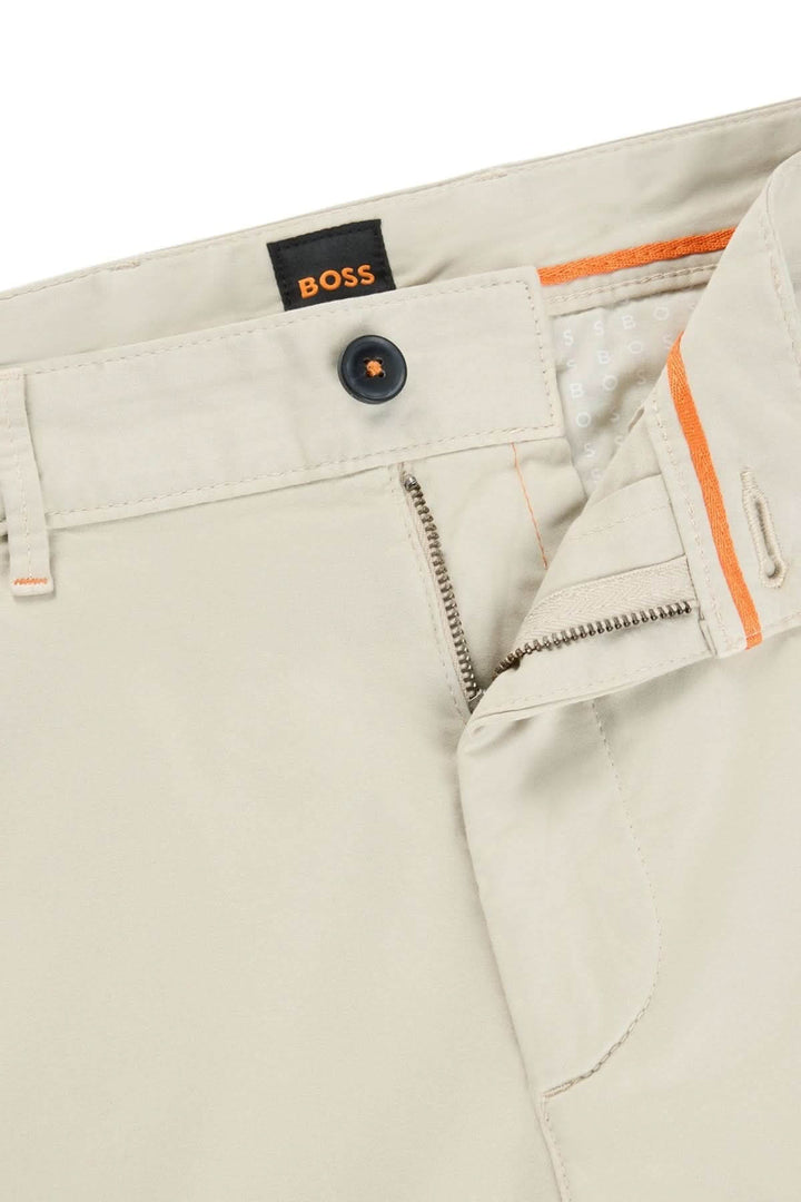 Pantalon chino slim beige BOSS, détail de la fermeture éclair et bouton pour un style moderne et élégant.