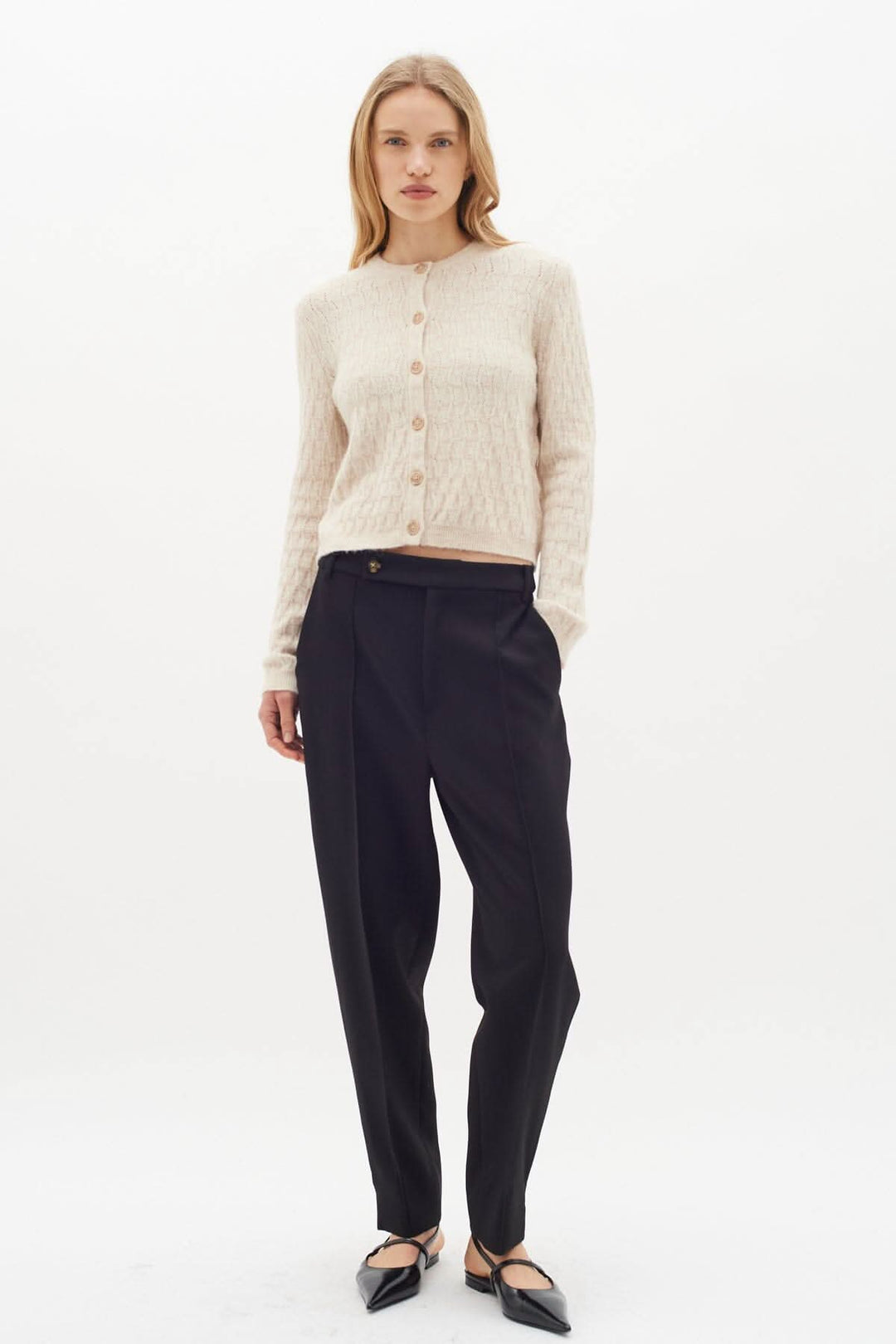 Pantalon classique Kail avec cardigan beige, look élégant et féminin, idéal pour un style raffiné.