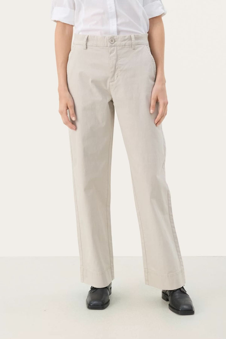 Pantalon à coupe droite beige avec silhouette moderne et épurée, parfait pour le bureau ou sorties décontractées en coton et élasthanne.