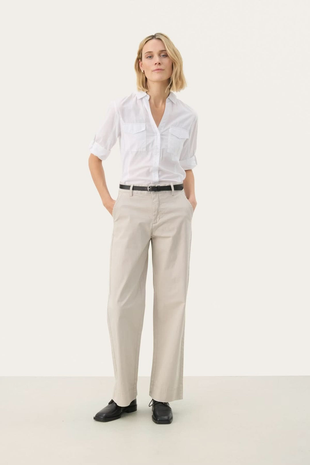 Modèle portant un pantalon à coupe droite en coton et élasthanne, élégant et confortable, idéal pour le bureau ou sorties décontractées.