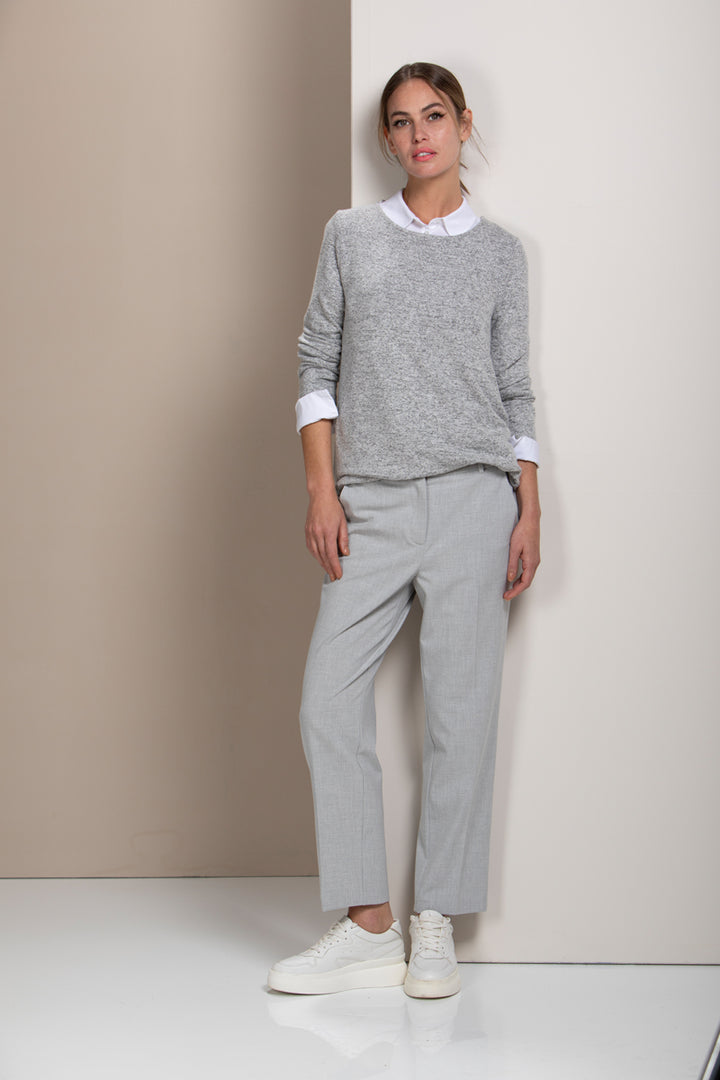 Femme portant un pantalon coupe droite gris, élégant et structuré, parfait pour le bureau ou quotidien, avec chemise et chandail gris.