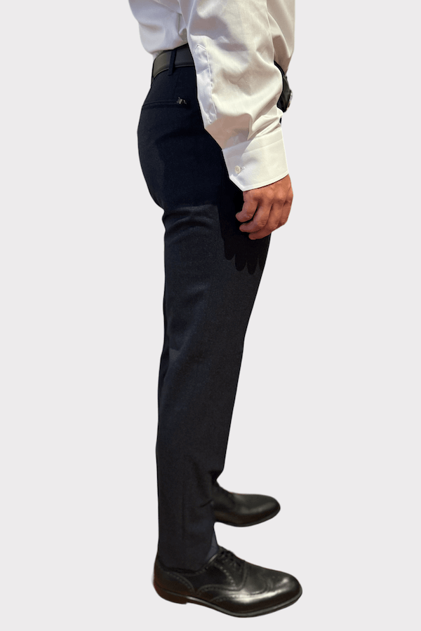 Pantalon de laine gris pour homme, coupe ajustée, porté avec une chemise blanche et des chaussures noires.