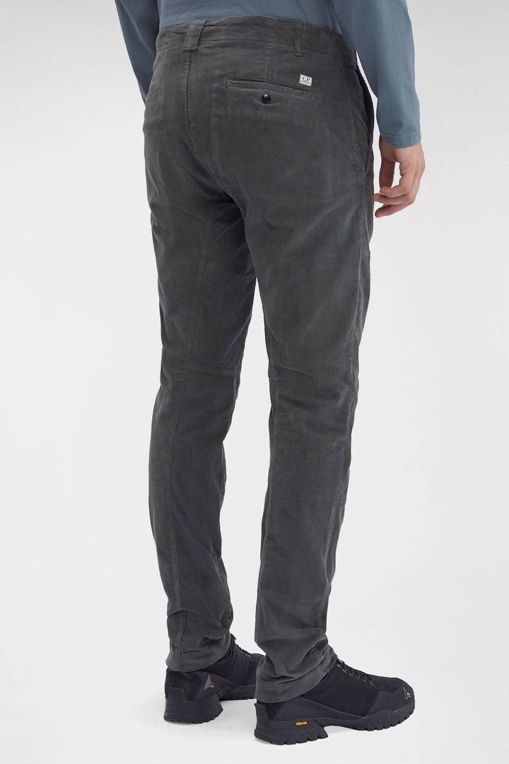 Pantalon en corduroy gris foncé avec poches et logo C.P. Company, coupe ergonomique vue arrière.