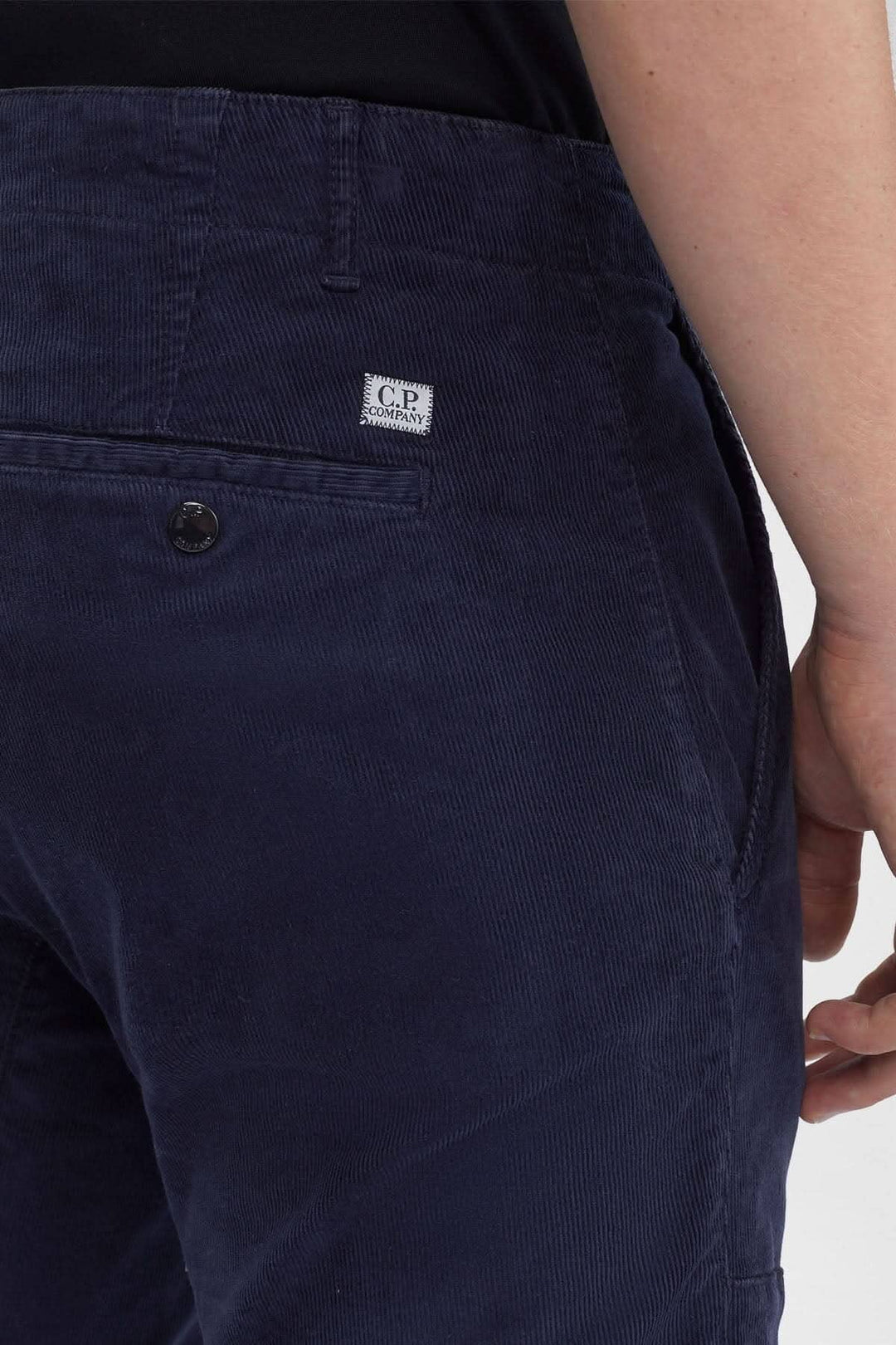 Pantalon en corduroy C.P. Company avec braguette zippée et poches arrière, couleur bleu marine.