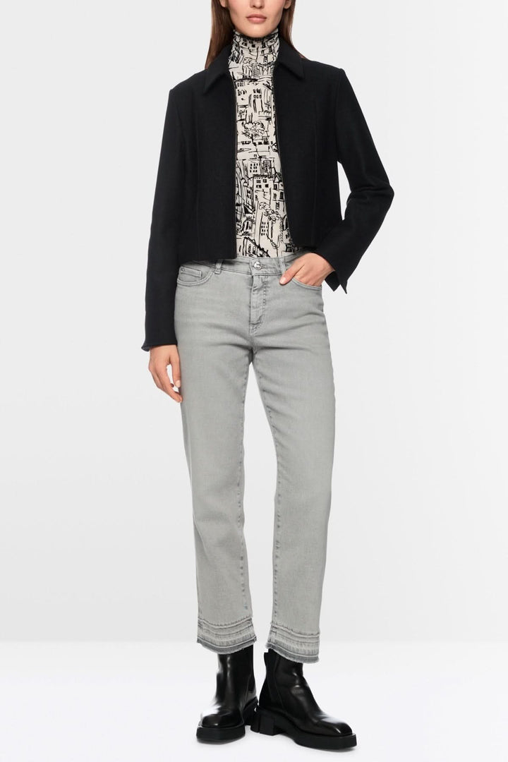 Pantalon en denim coupe droite et évasée avec fini effiloché, style moderne et décontracté pour femme, silhouette allongée.