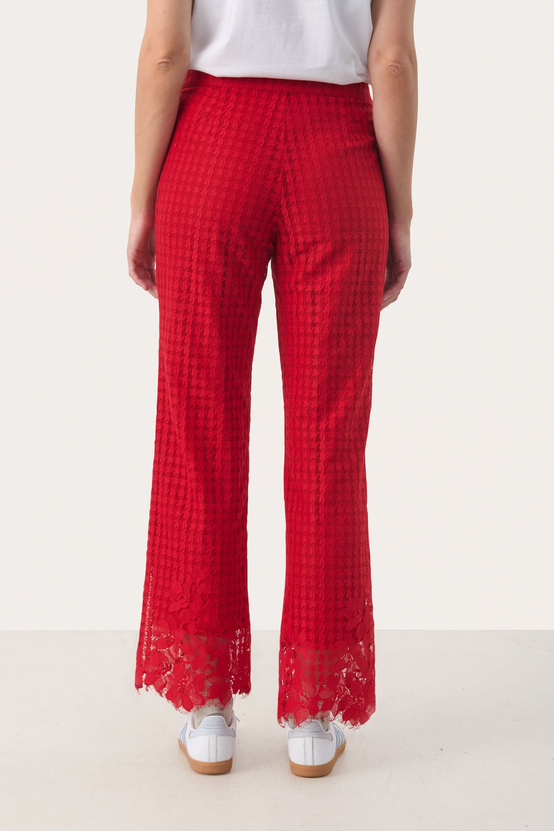 Pantalon en dentelle rouge à motif pied-de-poule, vue arrière, donnant une silhouette élégante et raffinée.