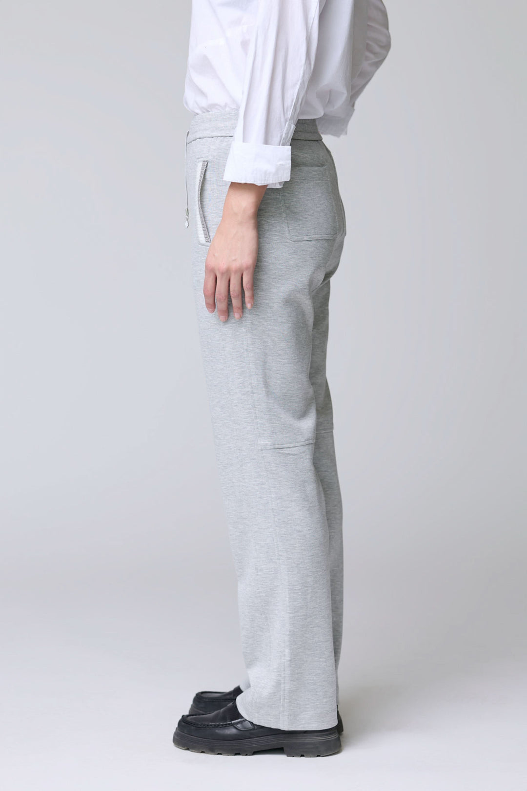 Pantalon en jersey ajustable gris avec taille élastique et poches latérales, vue latérale pour montrer confort et élégance décontractée.