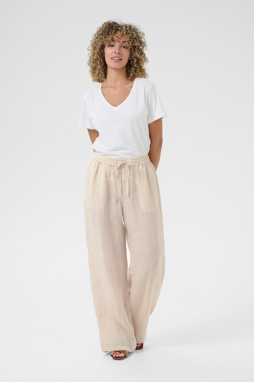Pantalon en lin léger avec taille élastique, porté avec un t-shirt blanc, idéal pour un look décontracté.