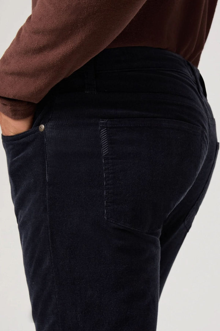 Pantalon en micro corduroy noir élégant, mettant en valeur une coupe ajustée et moderne.