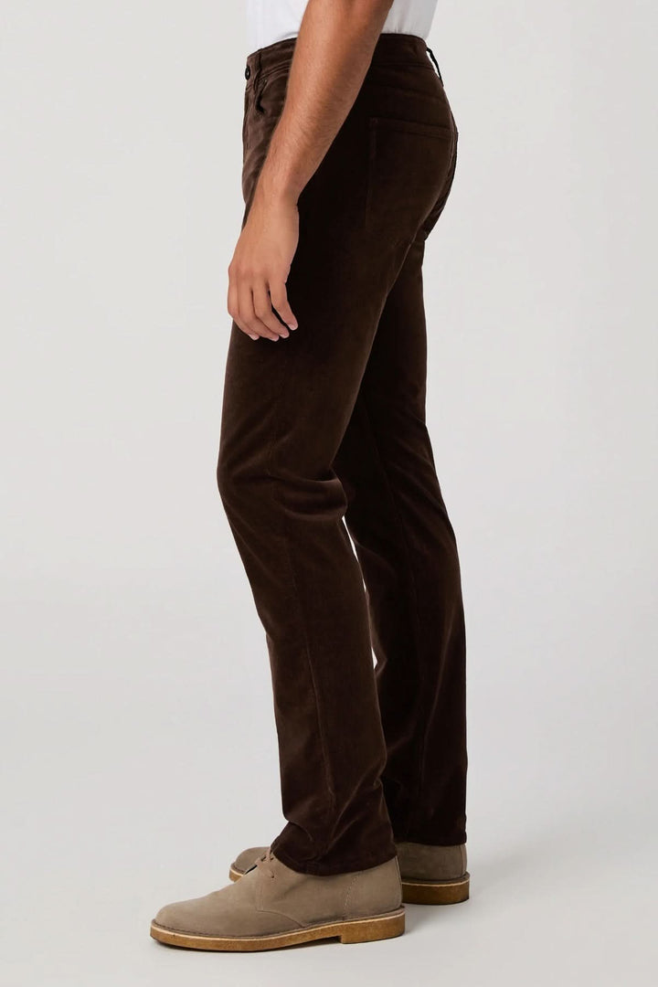 Homme portant un pantalon en micro corduroy marron de profil, soulignant l&