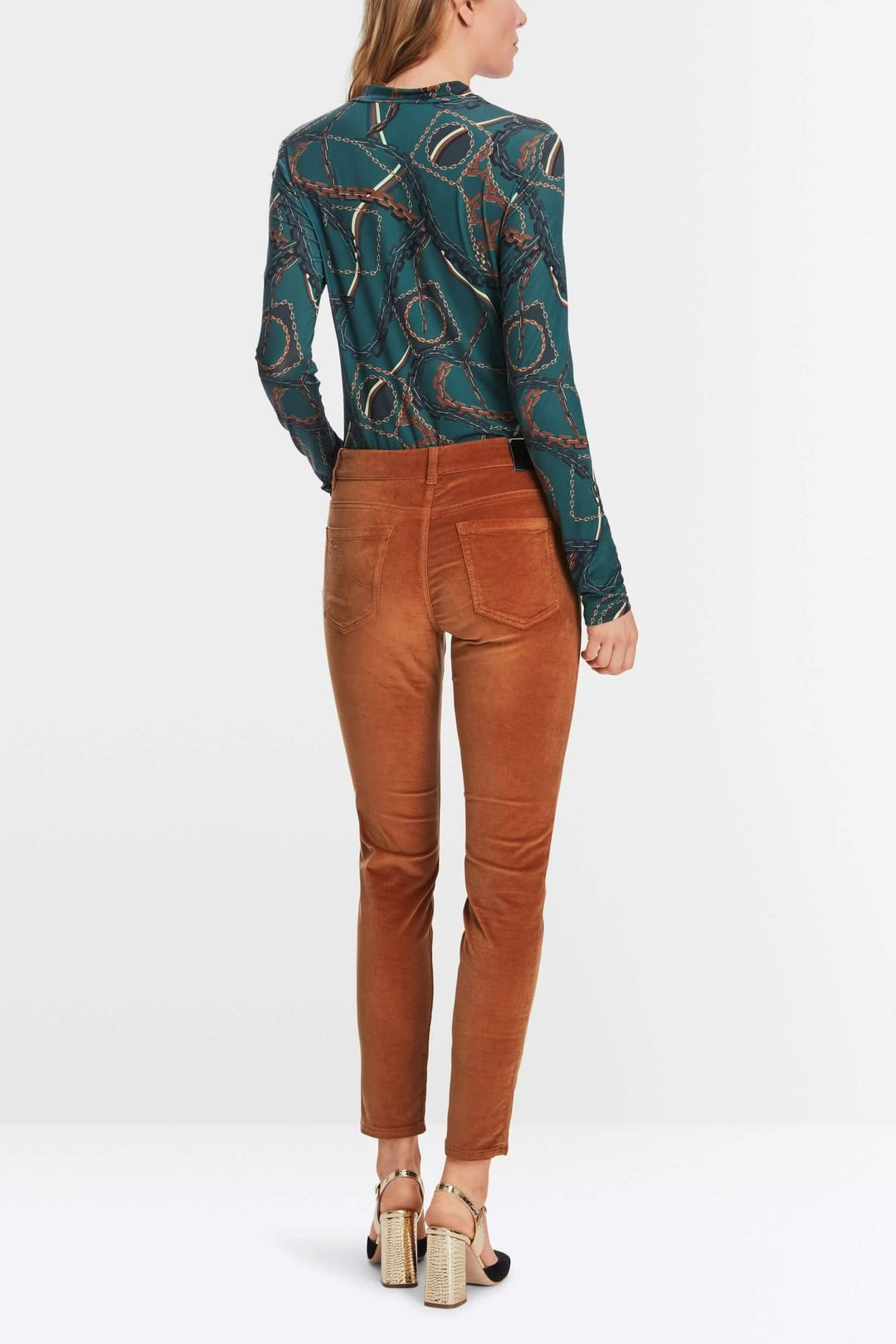 Femme vue de dos portant un pantalon en velours marron avec un top imprimé.