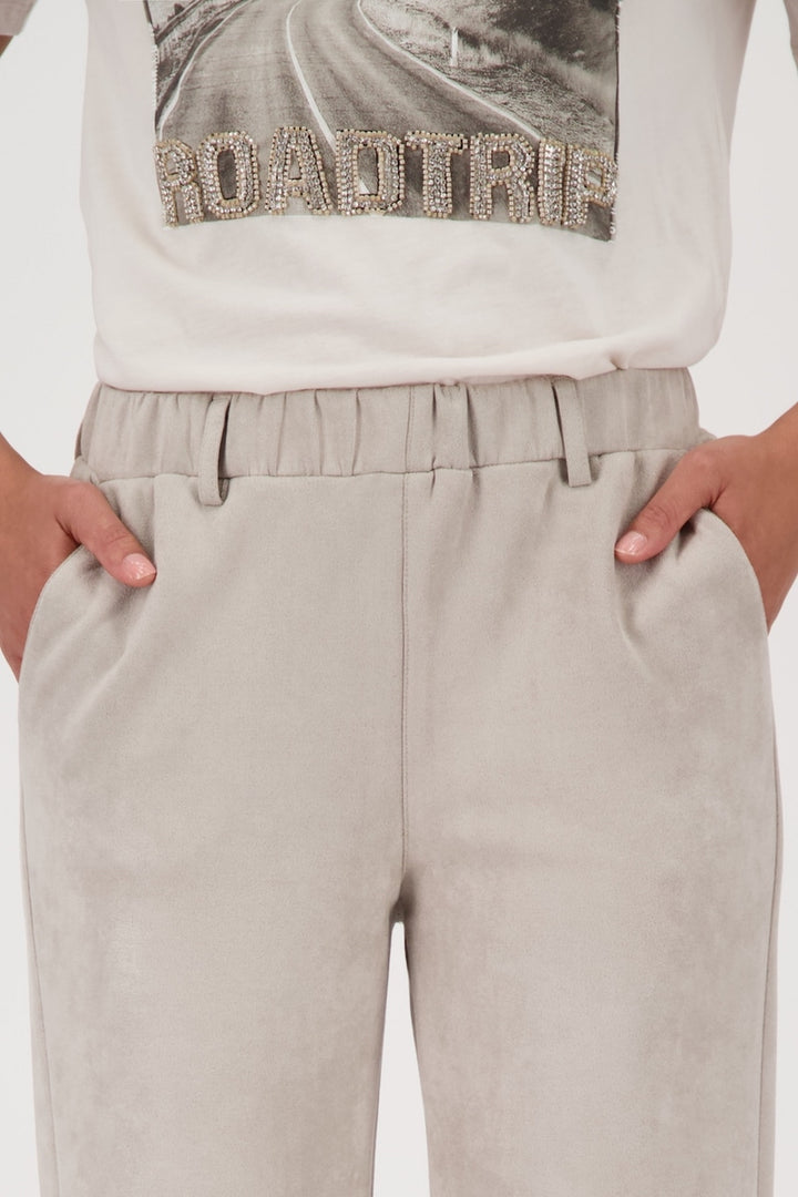 Pantalon habillé droit en similicuir et daim, poches fendues, ourlet élastiqué, style moderne.