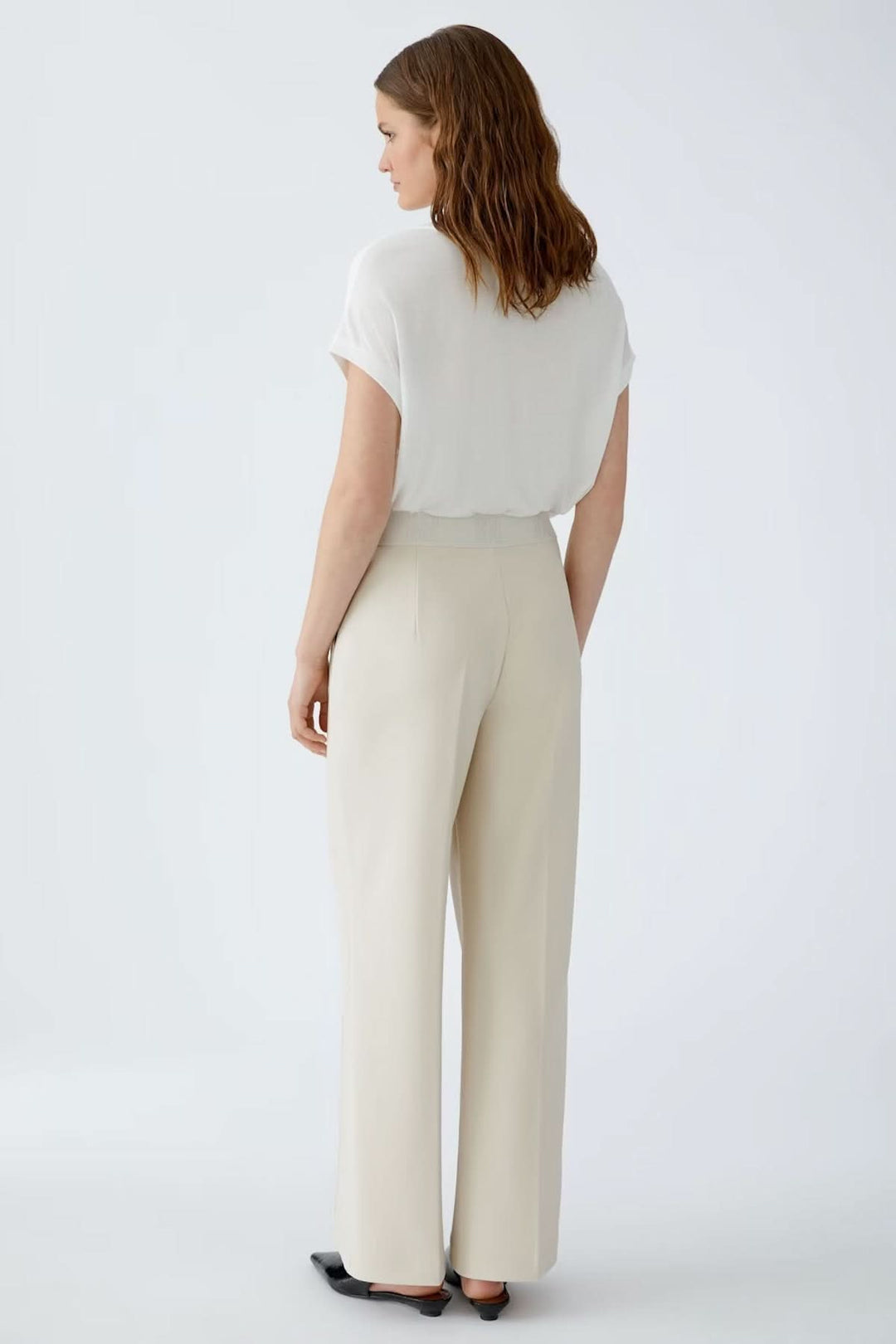 Femme portant un pantalon à jambe large en jersey technique avec ceinture élastique, vue arrière. Parfait pour une silhouette allongée.