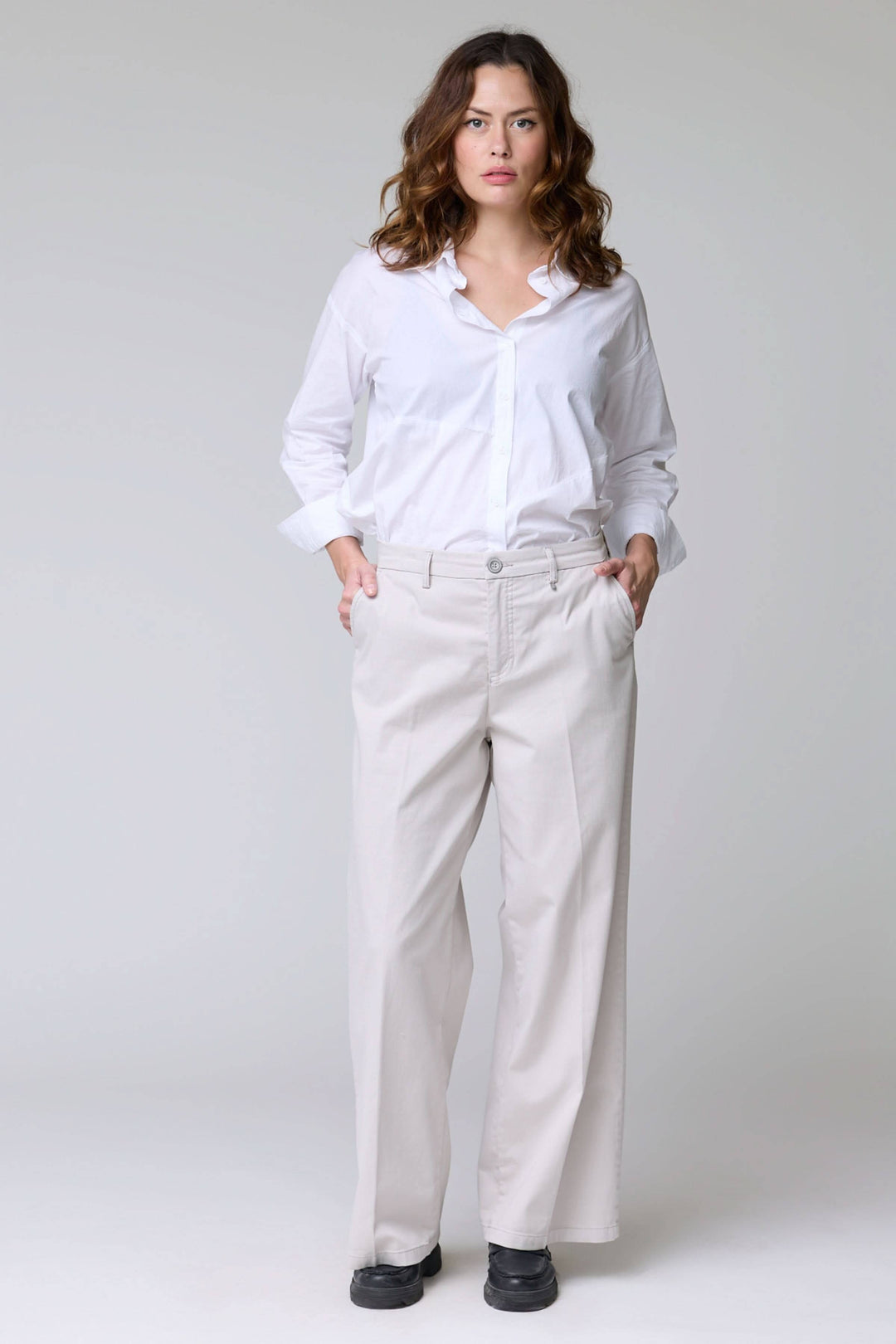 Femme portant un pantalon à jambe large, élégant et décontracté, avec poches latérales et ourlets nets. Tissu fluide et confortable.