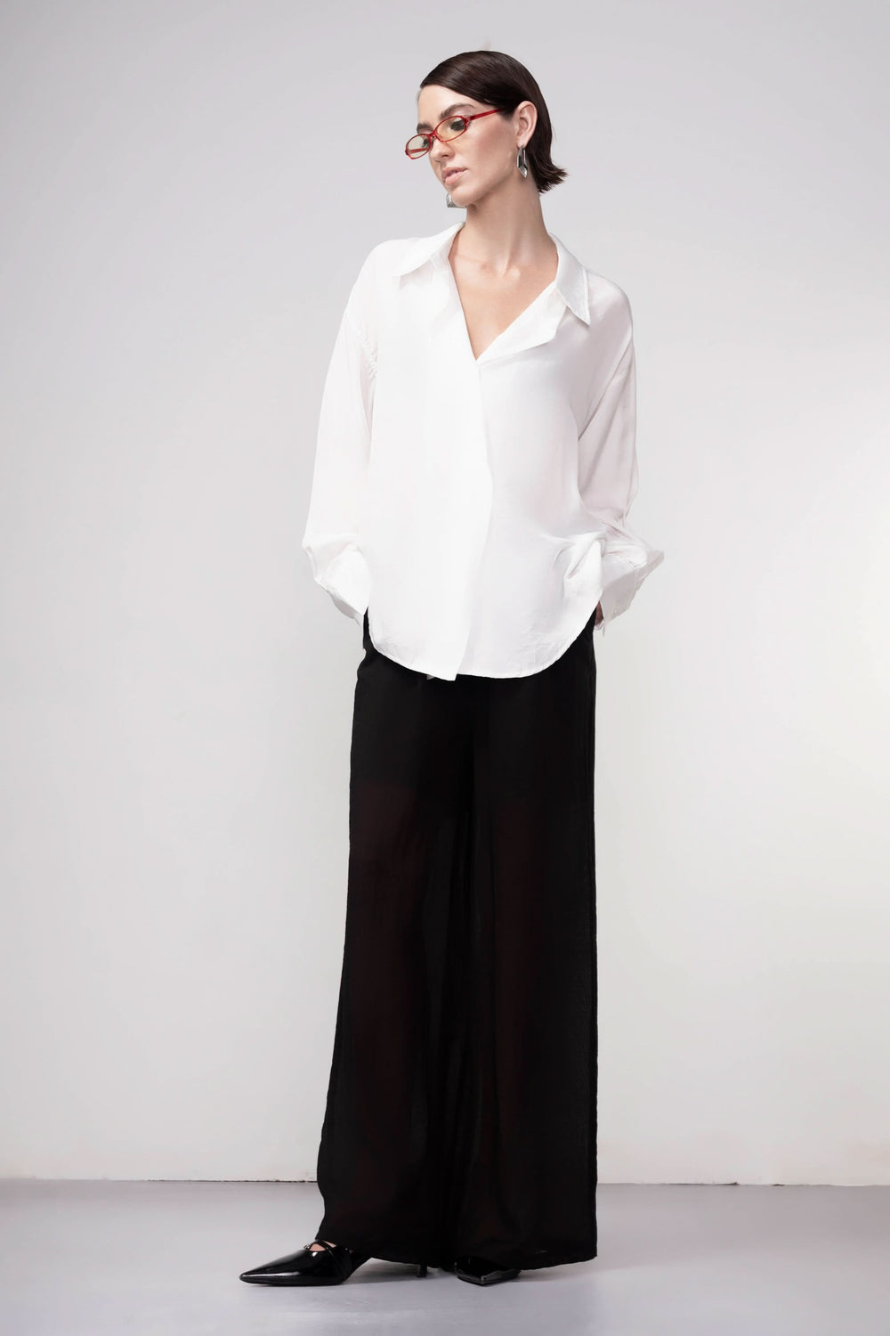 Pantalon jambe large noir avec taille élastique, coupe fluide. Parfait pour une tenue décontractée ou élégante. Mode moderne femme.