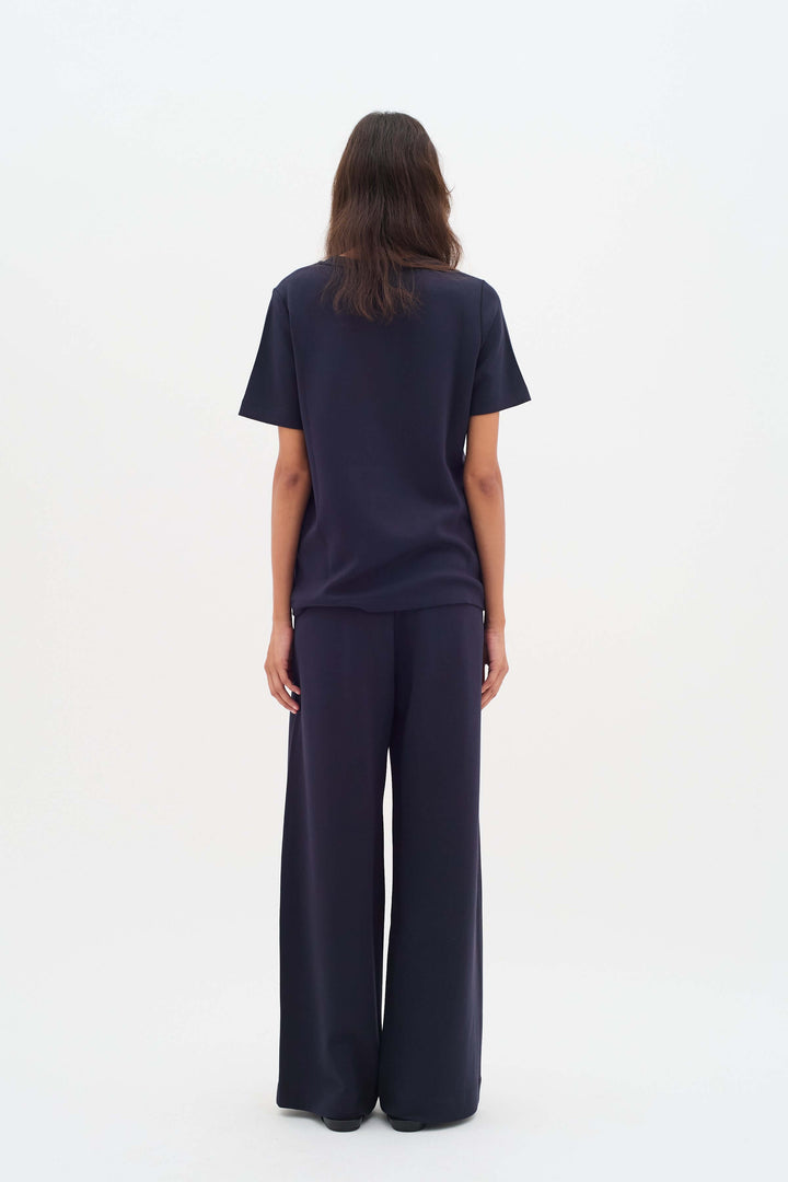 Vue arrière du pantalon à jambe large Gincette, offrant une silhouette fluide et élégante grâce à sa coupe ample et confortable.