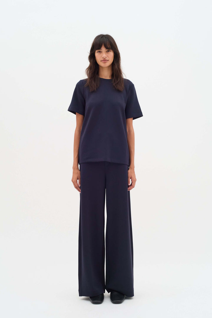 Femme portant le Pantalon à jambe large Gincette, style épuré et contemporain, silhouette fluide, idéal pour bureau et tenues habillées.