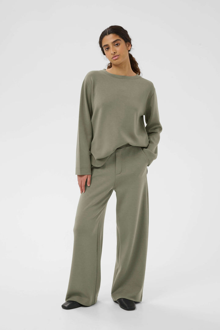 Femme portant un Pantalon à jambe large Gincette gris, style épuré et contemporain.