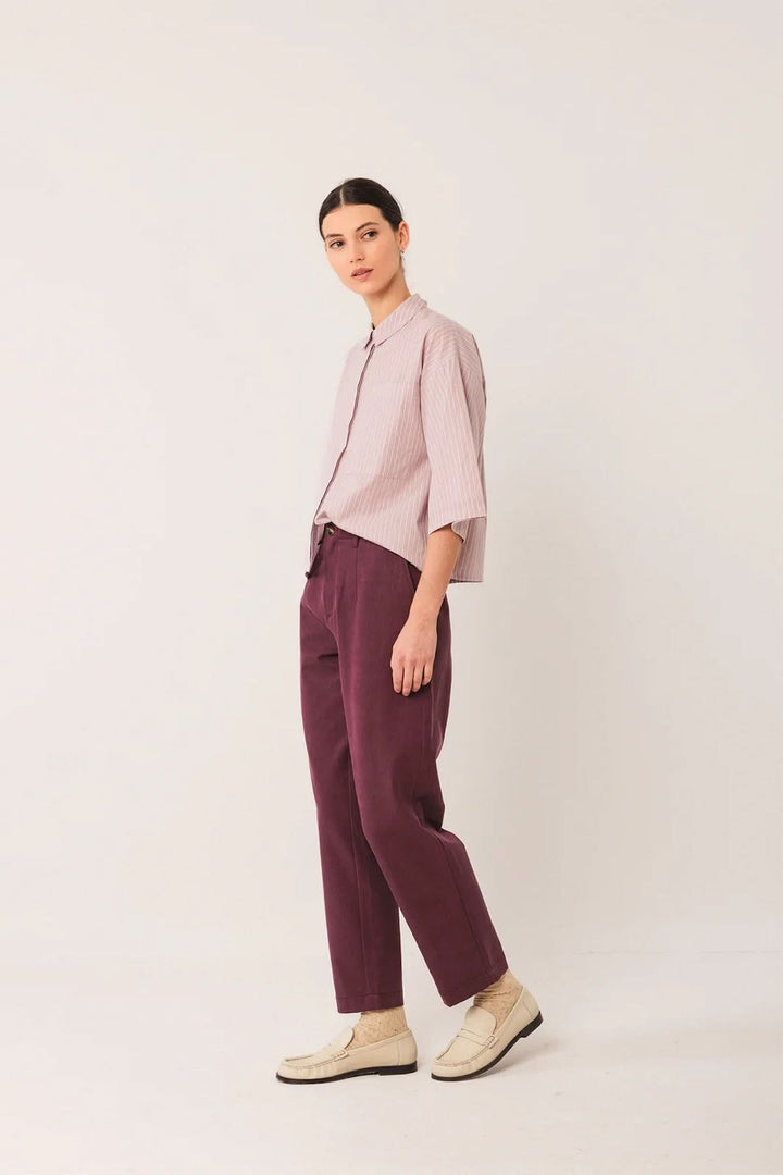 Femmes portant un Pantalon à la coupe droite prune avec chemise ample, soulignant confort et élégance moderne.