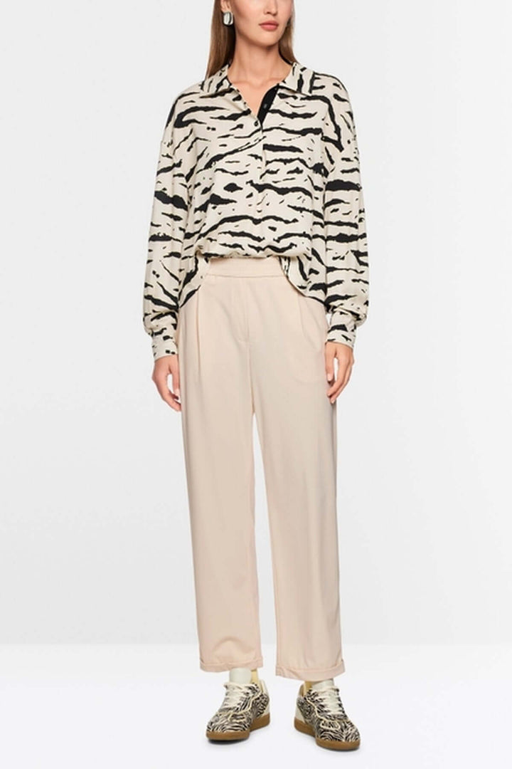 Femme portant le Pantalon léger WUXI avec un style décontracté et une touche sportive, accompagné de chaussures tendance.