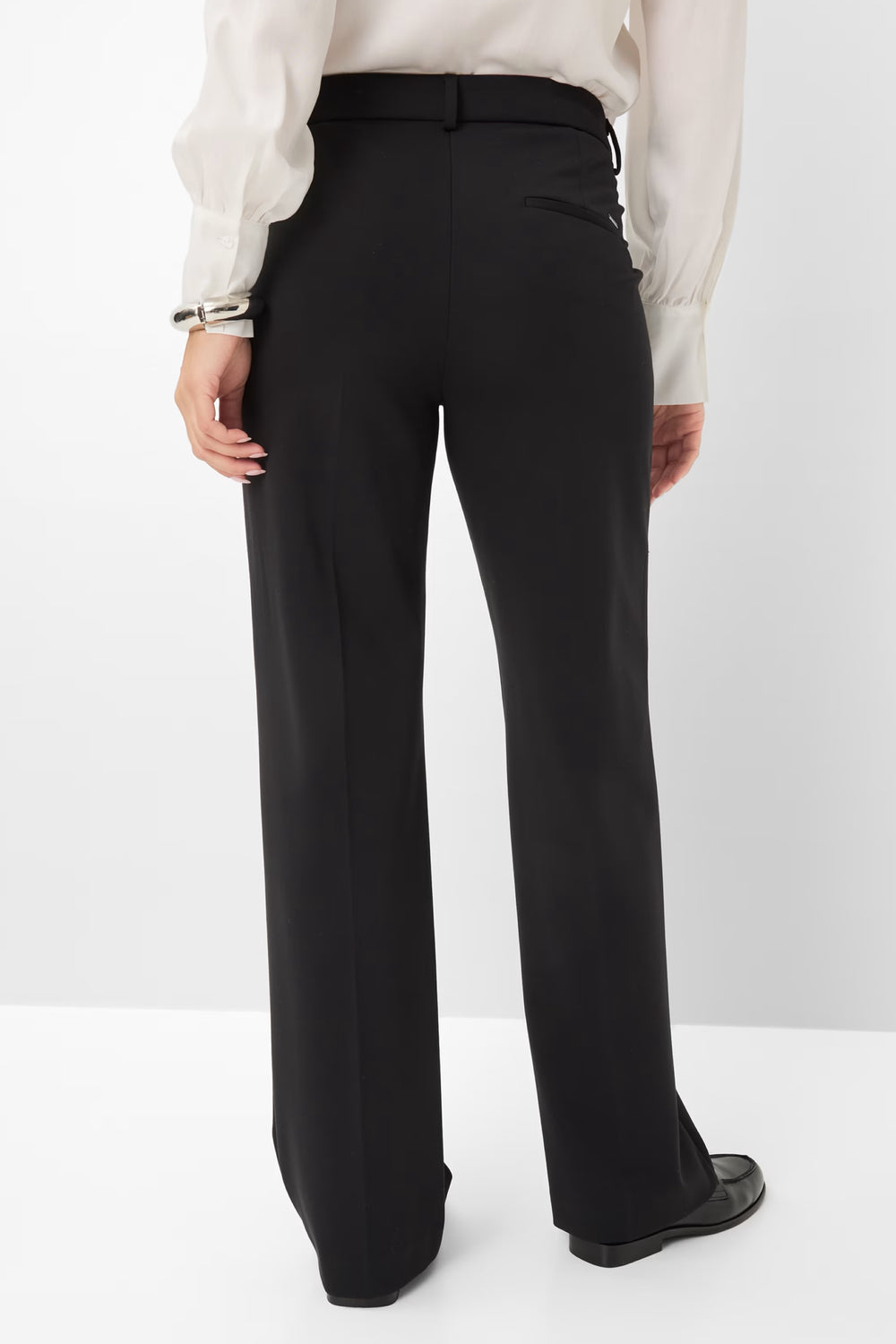 Pantalon palazzo noir à coupe large, porté avec une blouse élégante, vue de dos.