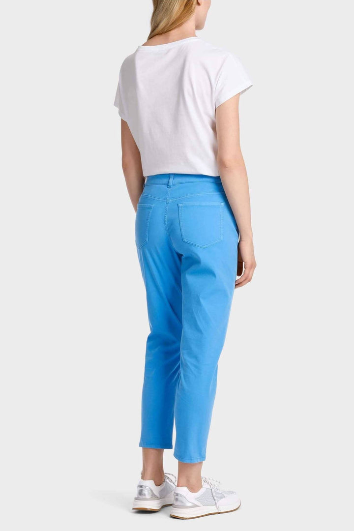 Pantalon décontracté bleu avec ourlet retroussé, porté avec un tee-shirt blanc et baskets blanches.