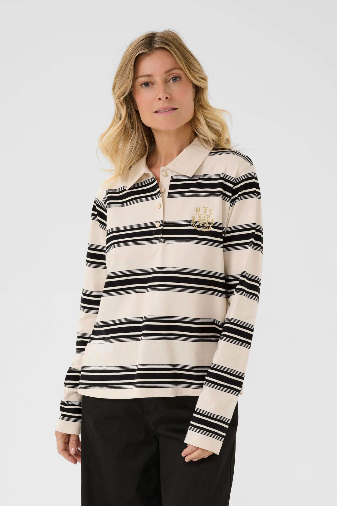 Femme portant Polo Carmell à rayures avec col classique, coupe droite et détail brodé, look casual chic confortable.
