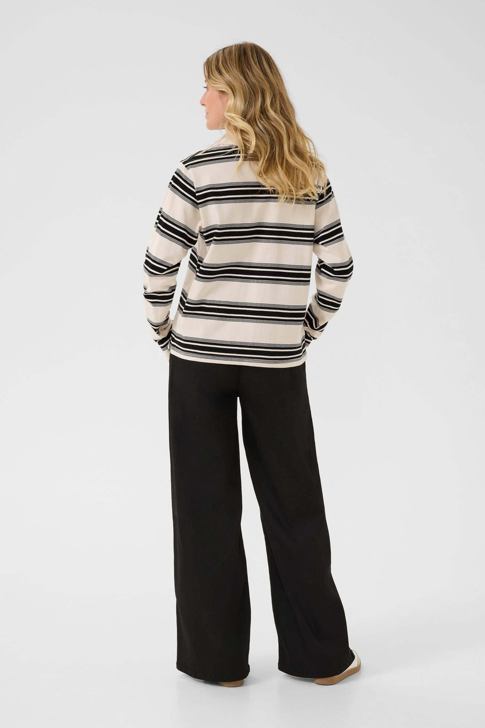 Femme portant un Polo Carmell rayé à col classique et coupe droite, élégant et confortable pour un style casual chic.