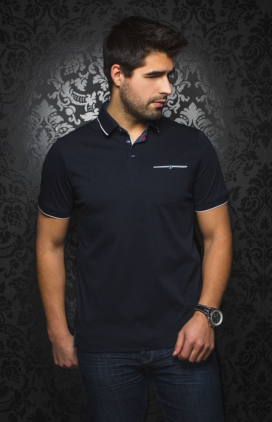 Homme portant un polo élégant à manches courtes, avec détails contrastants et poche poitrine sur fond noir.