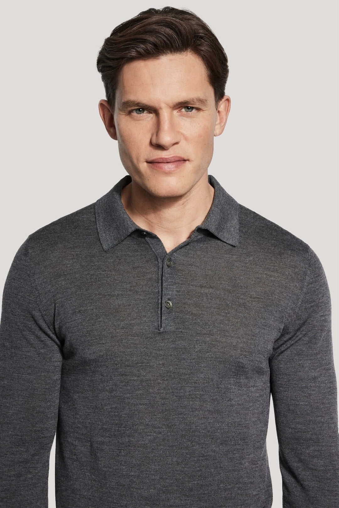 Homme portant un Polo manches longues en laine mérinos et soie, tricot maille fine, élégant et moderne, confortable pour toute occasion.