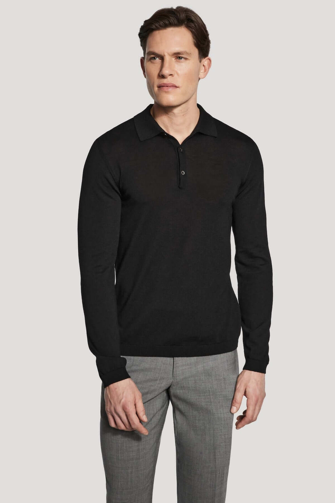 Homme portant un polo manches longues en laine mérinos et soie, coupe ajustée et élégante, adapté pour toutes occasions.
